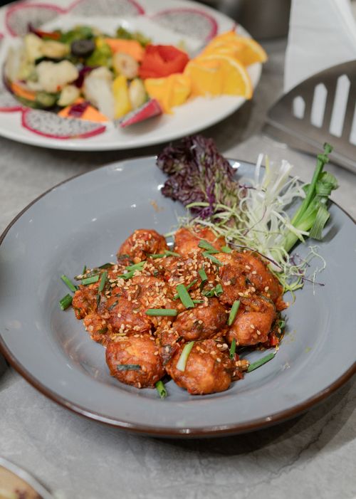 Free Delicious spicy Korean tofu garnished with sesame seeds and fresh vegetables served on a decorative plate. Stock Photo