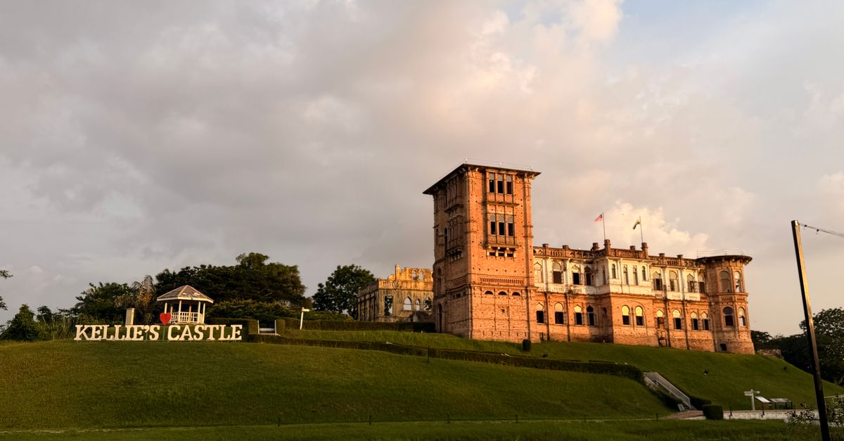 Dramatic view of Kellie's Castle in Malaysia during sunset with vibrant sky.