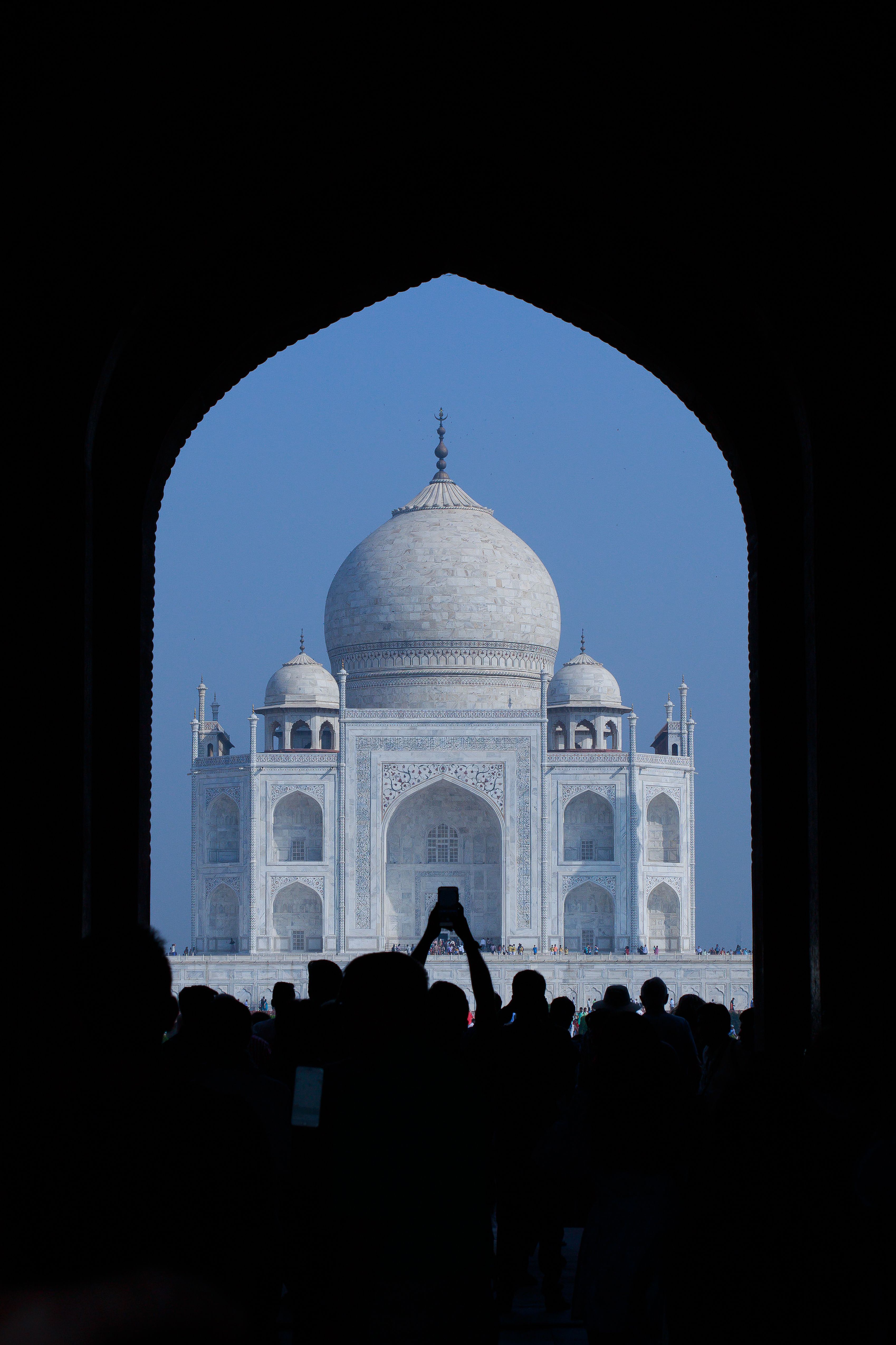 Silhouette of people viewing the Taj Mahal through an archway, Agra, India.