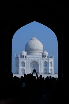 Silhouette of people viewing the Taj Mahal through an archway, Agra, India.