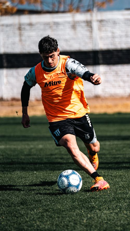 Free Dynamic shot of a young soccer player kicking a ball during outdoor practice. Stock Photo