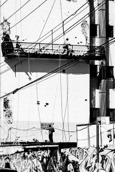 Black and white photo capturing construction activity on a building facade in New York City.