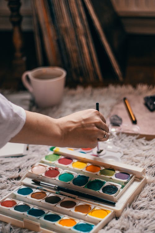 Artista Sin Rostro Que Mezcla Pinturas Brillantes Cerca De La Paleta De Colores En El Taller