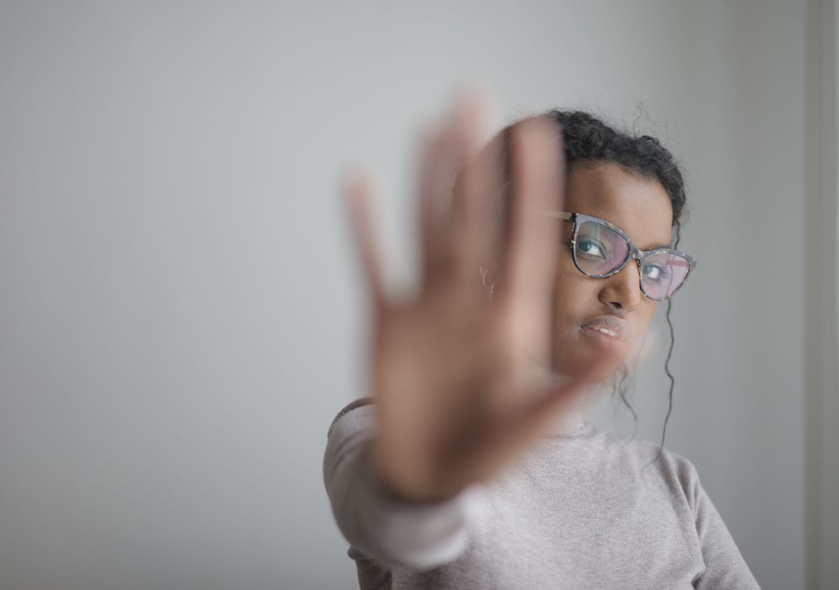 A person sticking their hand out, symbolizing setting boundaries