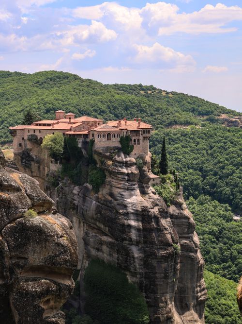 Free Scenic view of Meteora Monastery perched atop a cliff in Greece, surrounded by lush greenery. Stock Photo