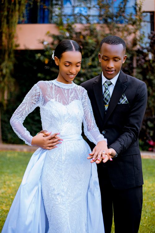 Free Bride and groom admiring wedding rings in a lush outdoor garden setting. Stock Photo