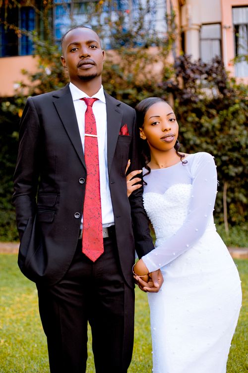 Free A sophisticated couple dressed formally poses in an outdoor garden setting. Stock Photo