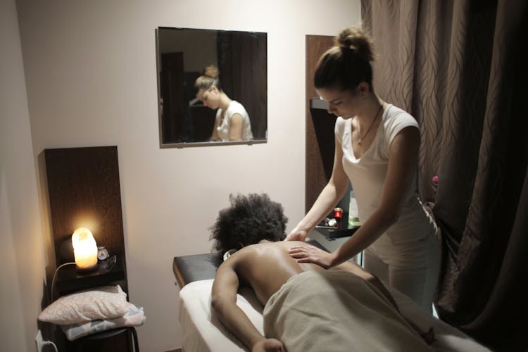 Professional Masseuse Doing Massage Of Back Of Client In Salon