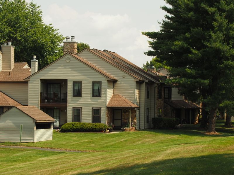 Suburban homes on a green, tree-lined street