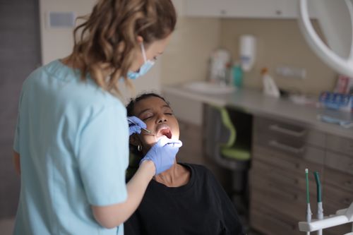 Free A female dentist performs a dental check-up on a patient in a clinic. Stock Photo