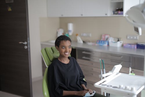 Free Surprised young ethnic female patient in dental chair in modern clinic Stock Photo
