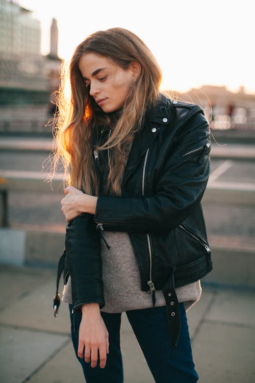 Tranquil young lady chilling in city park during sunset