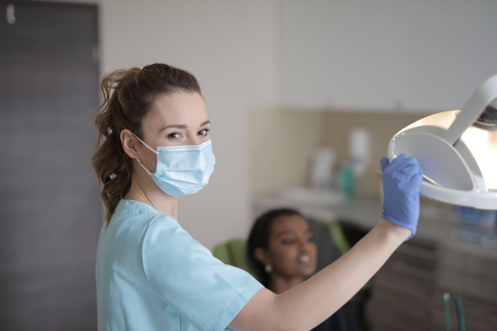 Dentista a examinar paciente sorridente numa clínica moderna