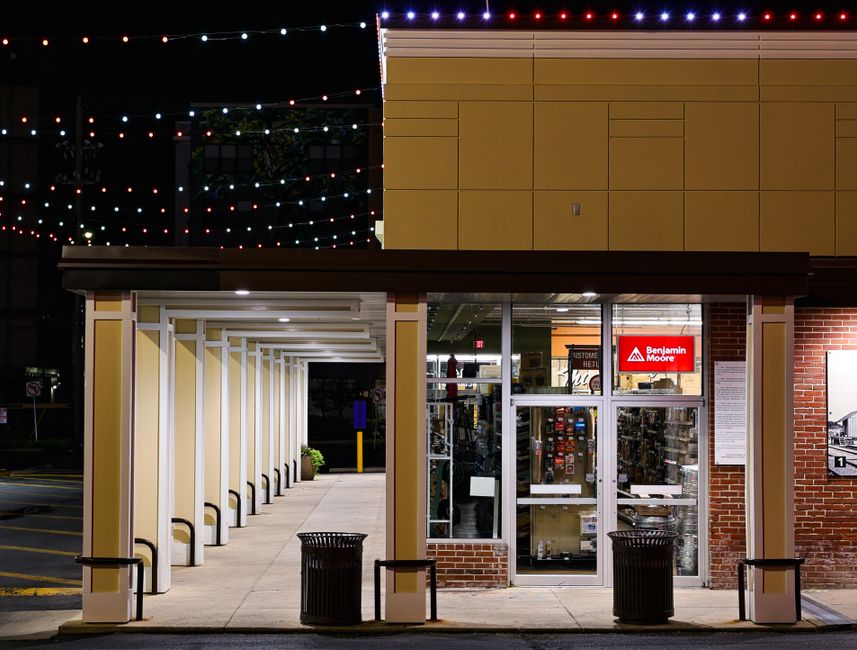 Captivating night view of a Benjamin Moore storefront adorned with string lights.