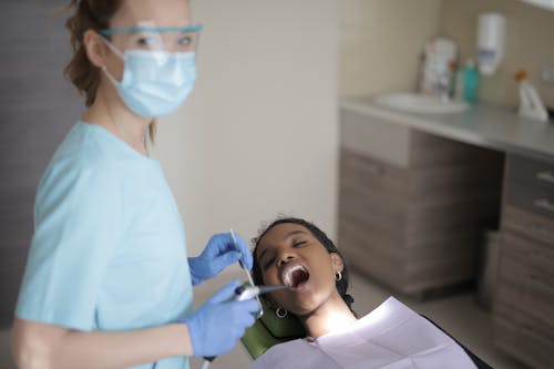 A Dentist At Work With Her Patient