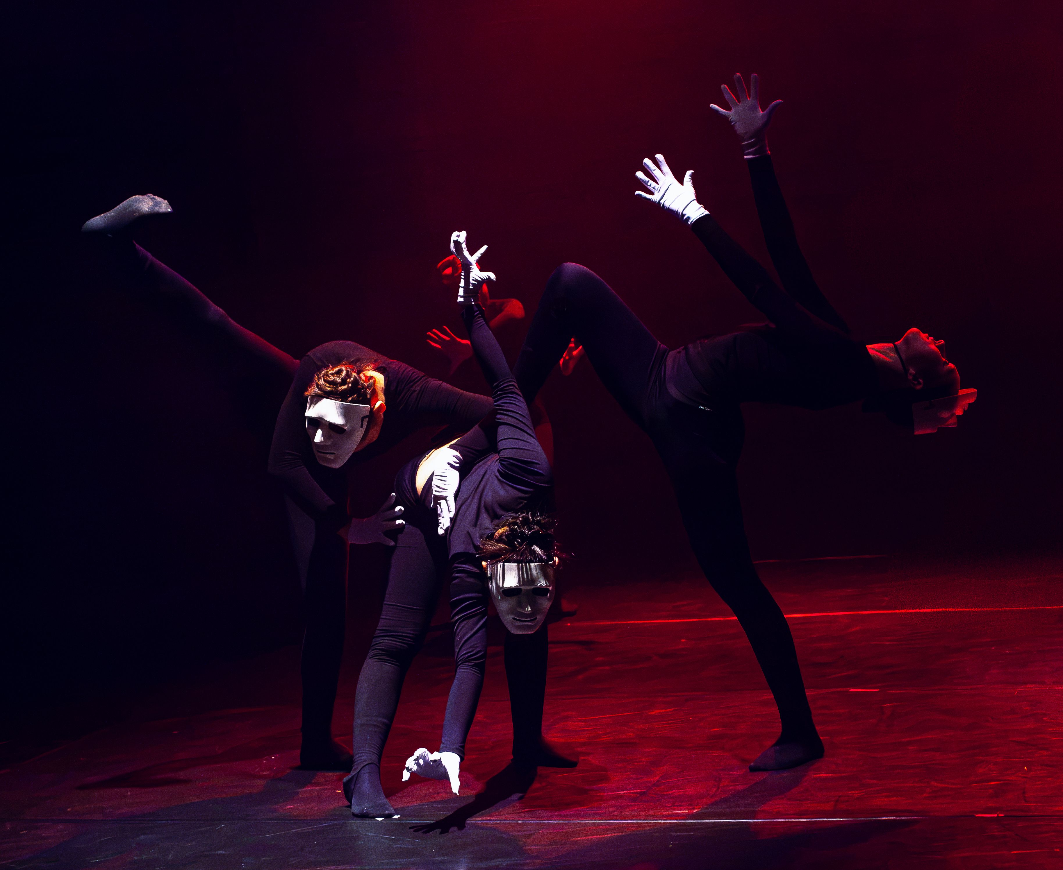 Artistic dance performance with masked dancers on a dimly lit stage. - Evidence evidence guide for black tea visual performance randomized trial