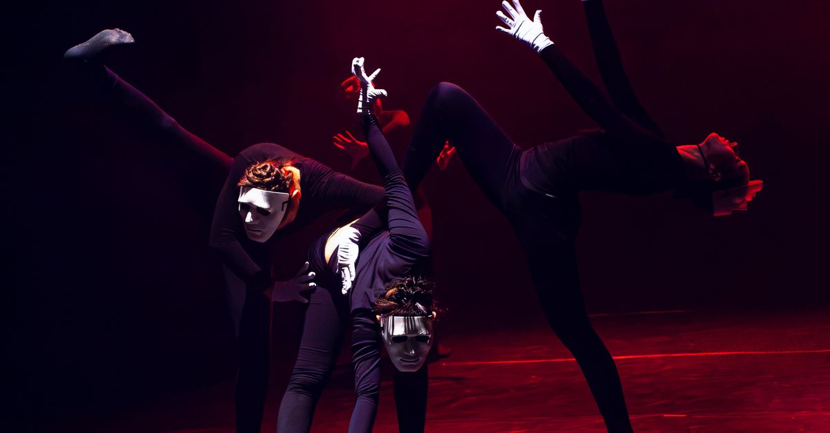 Artistic dance performance with masked dancers on a dimly lit stage. - Evidence evidence guide for black tea visual performance randomized trial