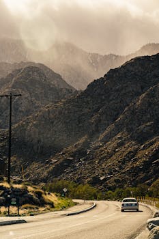 日落时分，汽车行驶在风景秀丽的山路上，呈现出一片宁静如画的景色