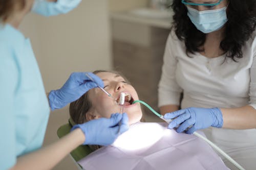 Woman Having Her Teeth Checked By A Dentist