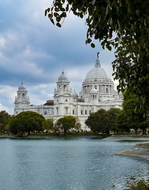 Free Beautiful view of the Victoria Memorial in Kolkata, surrounded by greenery and a tranquil lake. Stock Photo