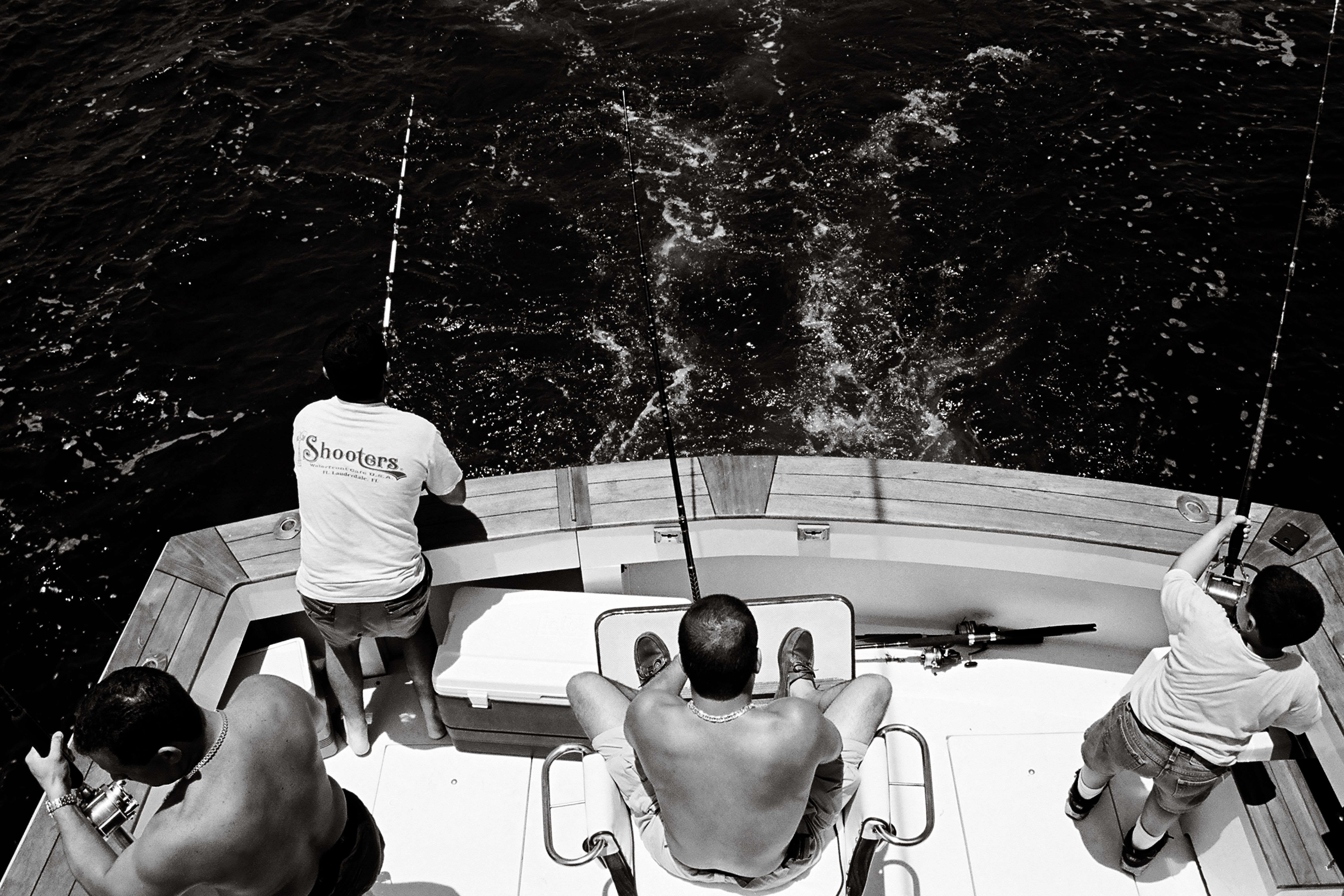 Four men engaged in fishing from a boat in Key West, showcasing a leisure activity on the water.