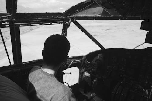 Unrecognizable person sitting in pilot cabin during flight