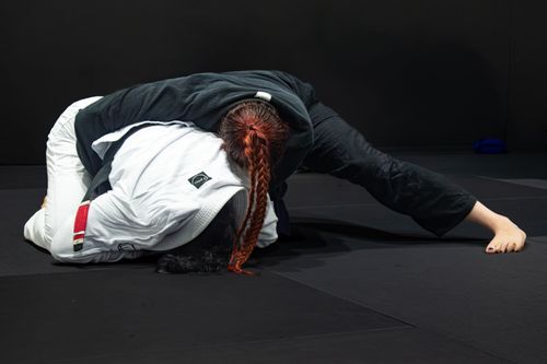 Free Two athletes engaging in a jiu-jitsu grappling session on a mat indoors. Stock Photo