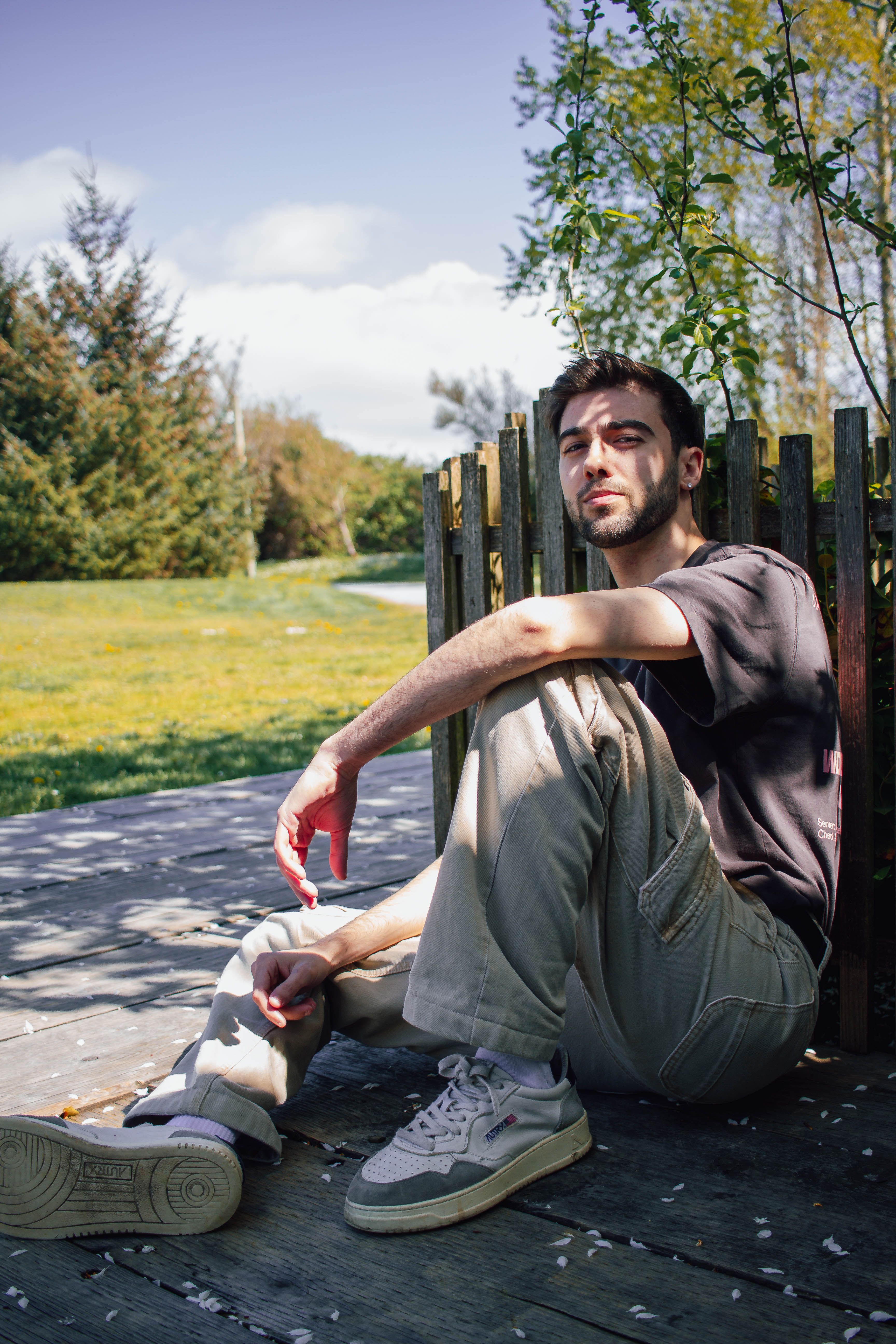 Casual young man sitting and relaxing on a sunny day in Vancouver park.