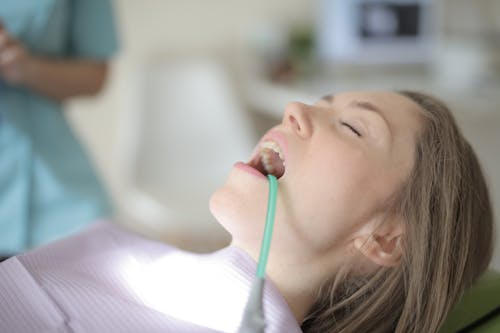 Young female patient healing teeth in modern clinic