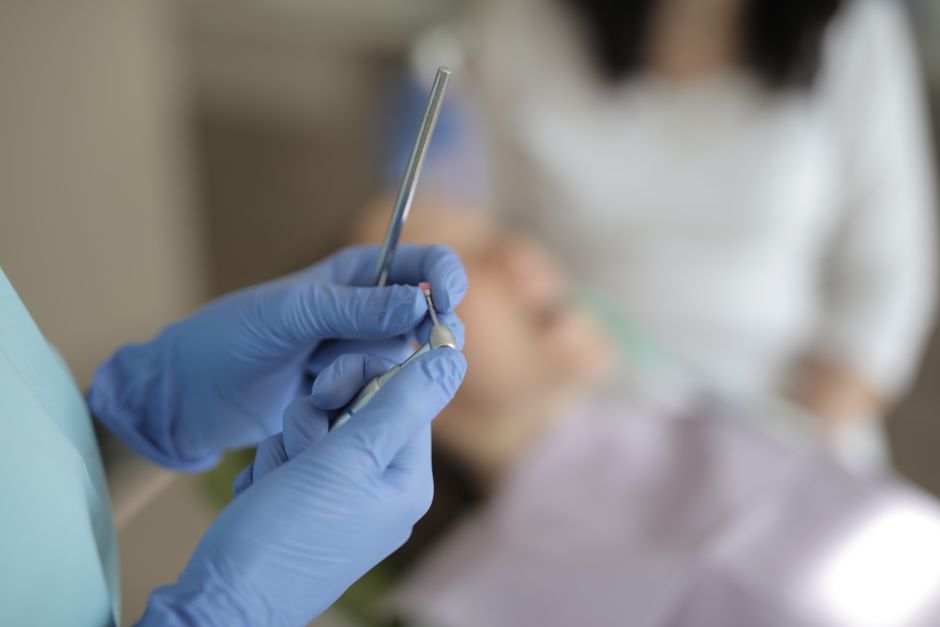 Dentist preparing a tooth for a crown placement Dentist preparing a tooth for a crown placement