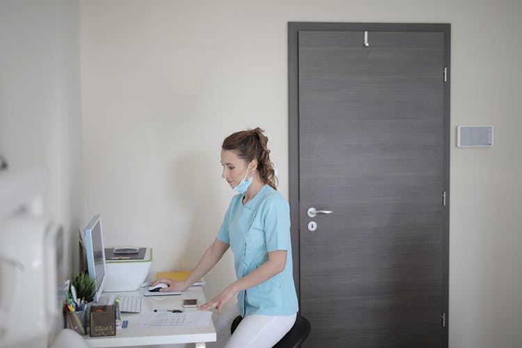 Young Female Doctor Working With Computer In Modern Clinic