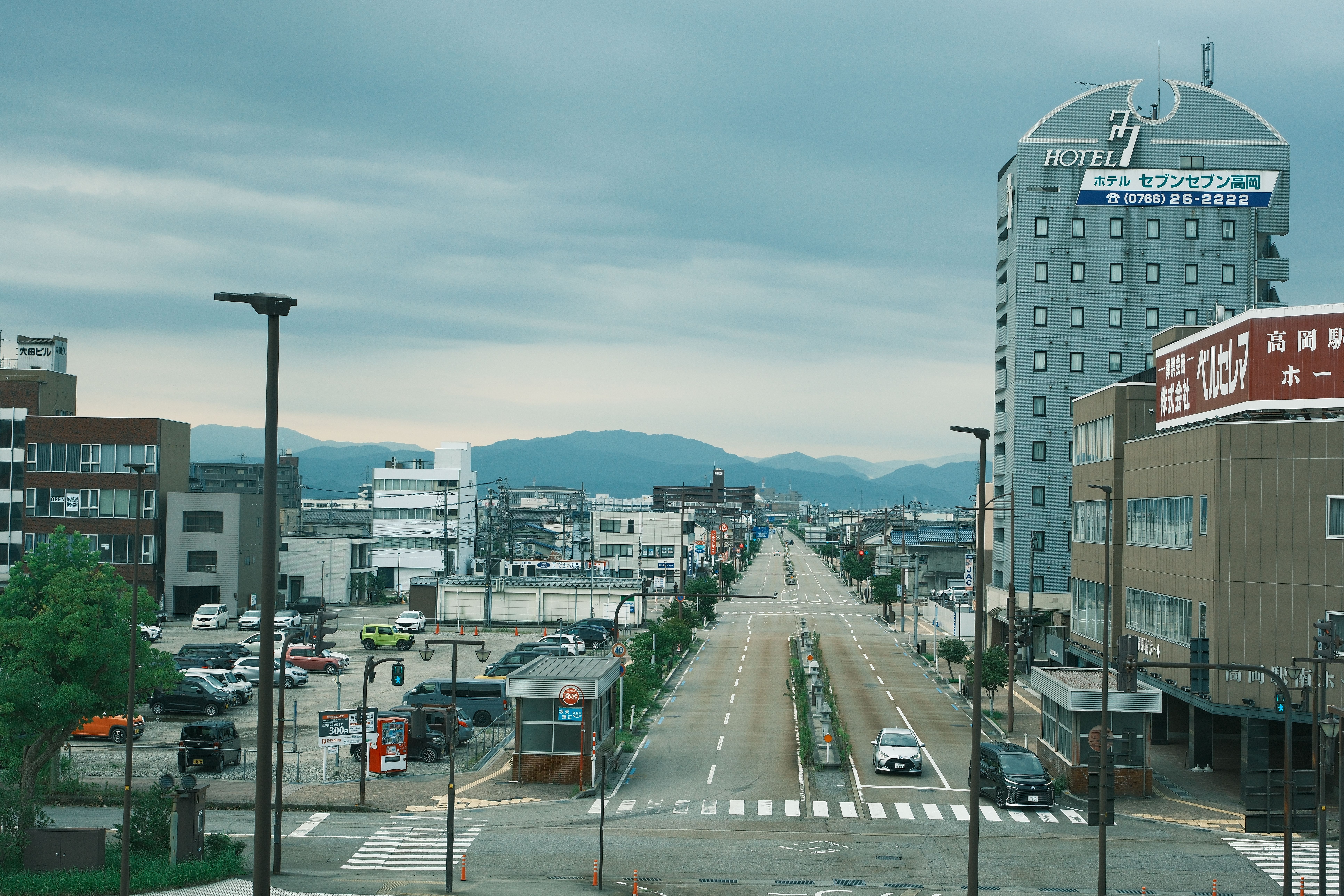 A wide shot of Takamatsu city with overcast skies and a central road view from above.