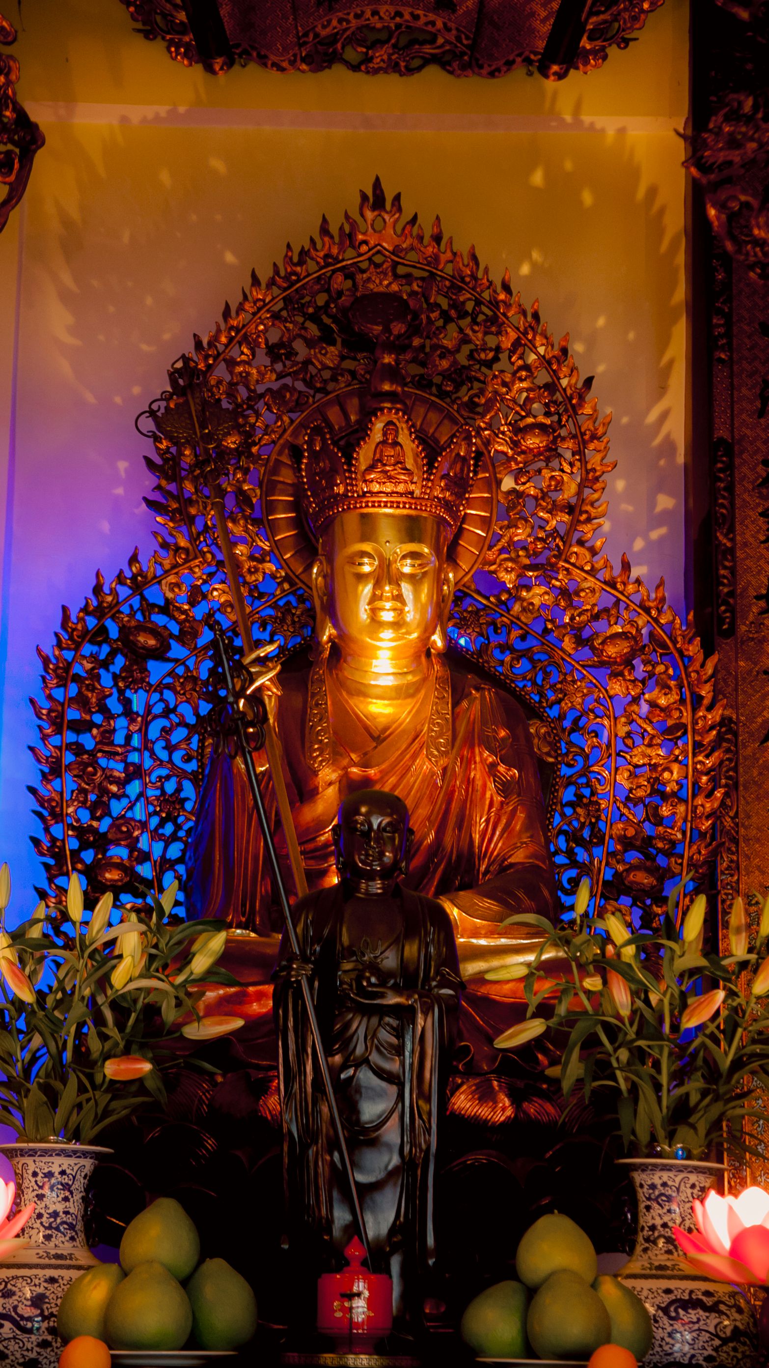 Ornate golden Buddha statue with vivid lighting at a temple in Ho Chi Minh City, Vietnam.