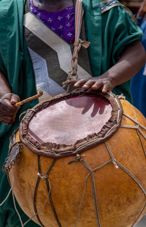 Free Close-up of a hand playing a traditional African drum, showcasing vibrant cultural attire. Stock Photo