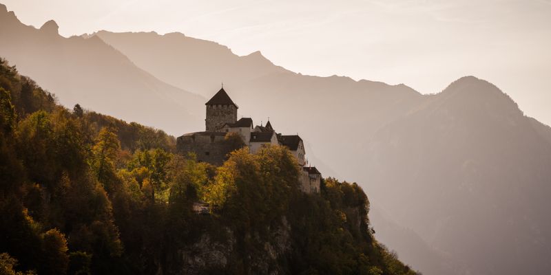 El castillo de Vaduz entre montañas en otoño