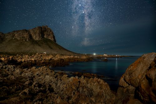 Free Dazzling stars over Pringle Bay's rocky coast and Milky Way galaxy, Western Cape, South Africa. Stock Photo