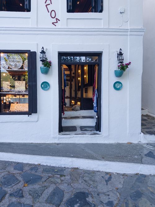 Free White-washed shop facade with colorful decor and open entrance in Skopelos, Greece. Stock Photo
