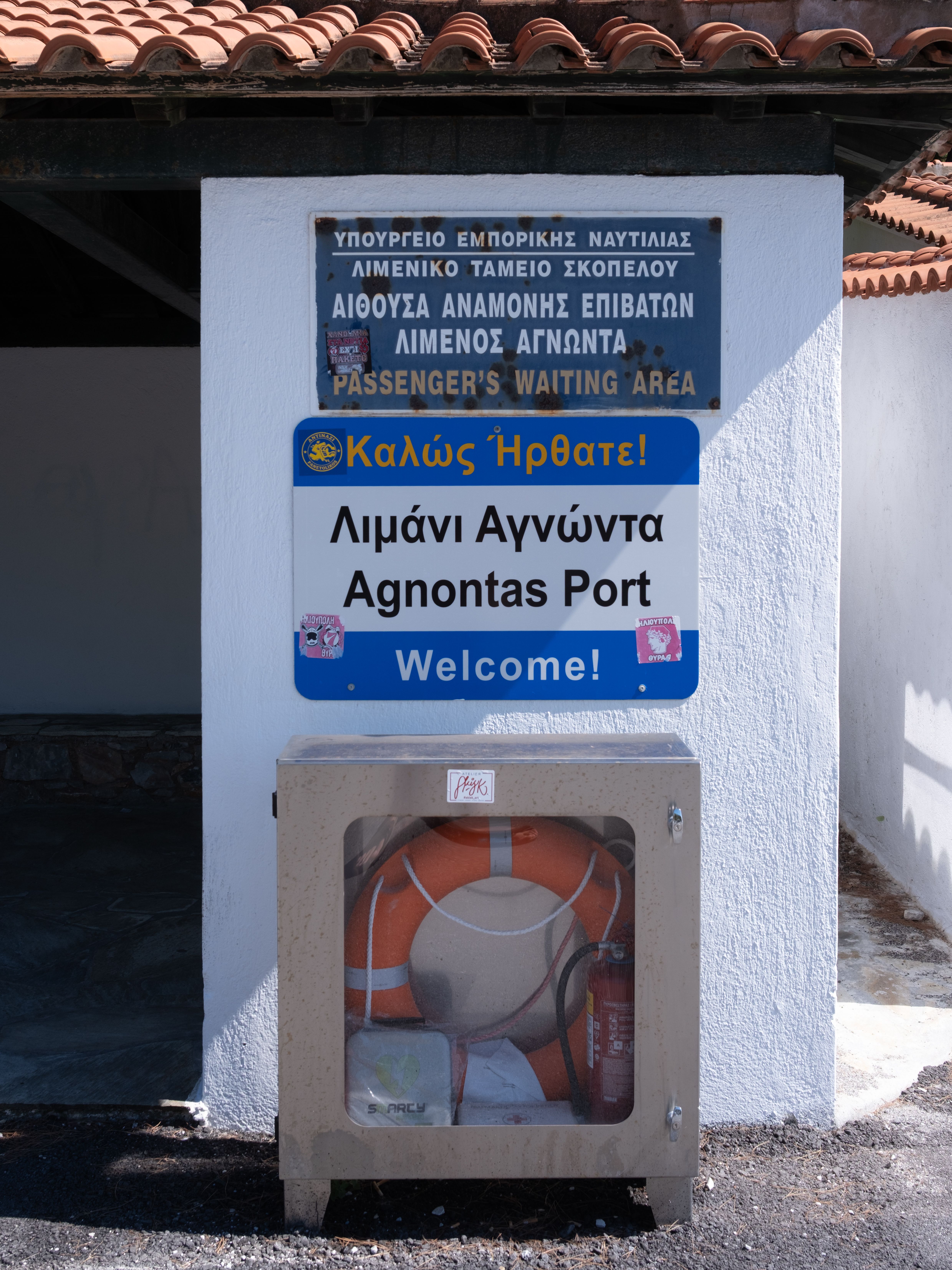 Agnontas Port passenger sign in Skopelos, Greece welcomes visitors.