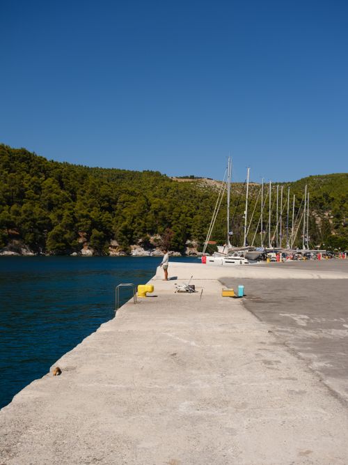 Free Peaceful marina in Skopelos, Greece with sailboats and a sunny blue sky. Stock Photo