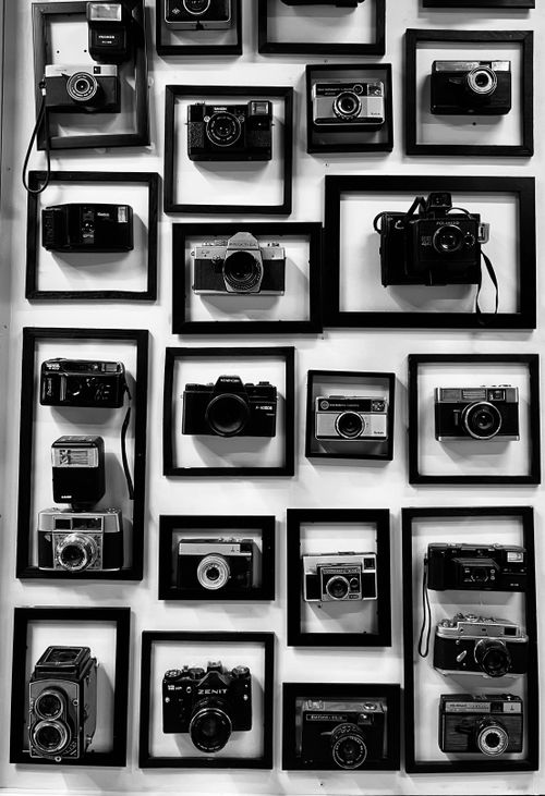Free A striking display of various vintage cameras in black and white, arranged artfully in frames. Stock Photo