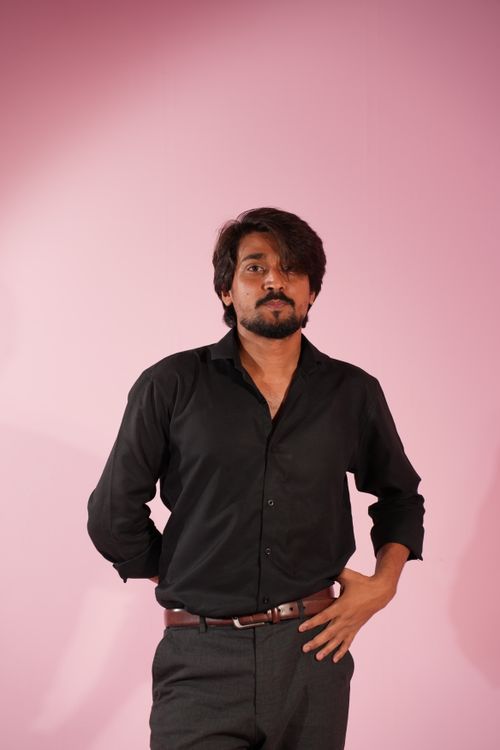 Free Portrait of a confident man in black shirt posing against a pink background. Stock Photo