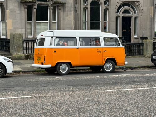 Free Vintage orange VW camper van parked on a city street, Edinburgh. Stock Photo