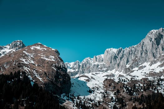 Snow-covered peaks of Malga Cassinelli, Italy under a clear blue sky. Scenic winter landscape.