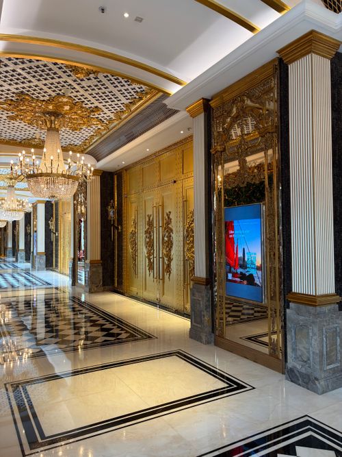 Free Opulent hotel hallway in Hong Kong, featuring gold decor and chandeliers. Stock Photo