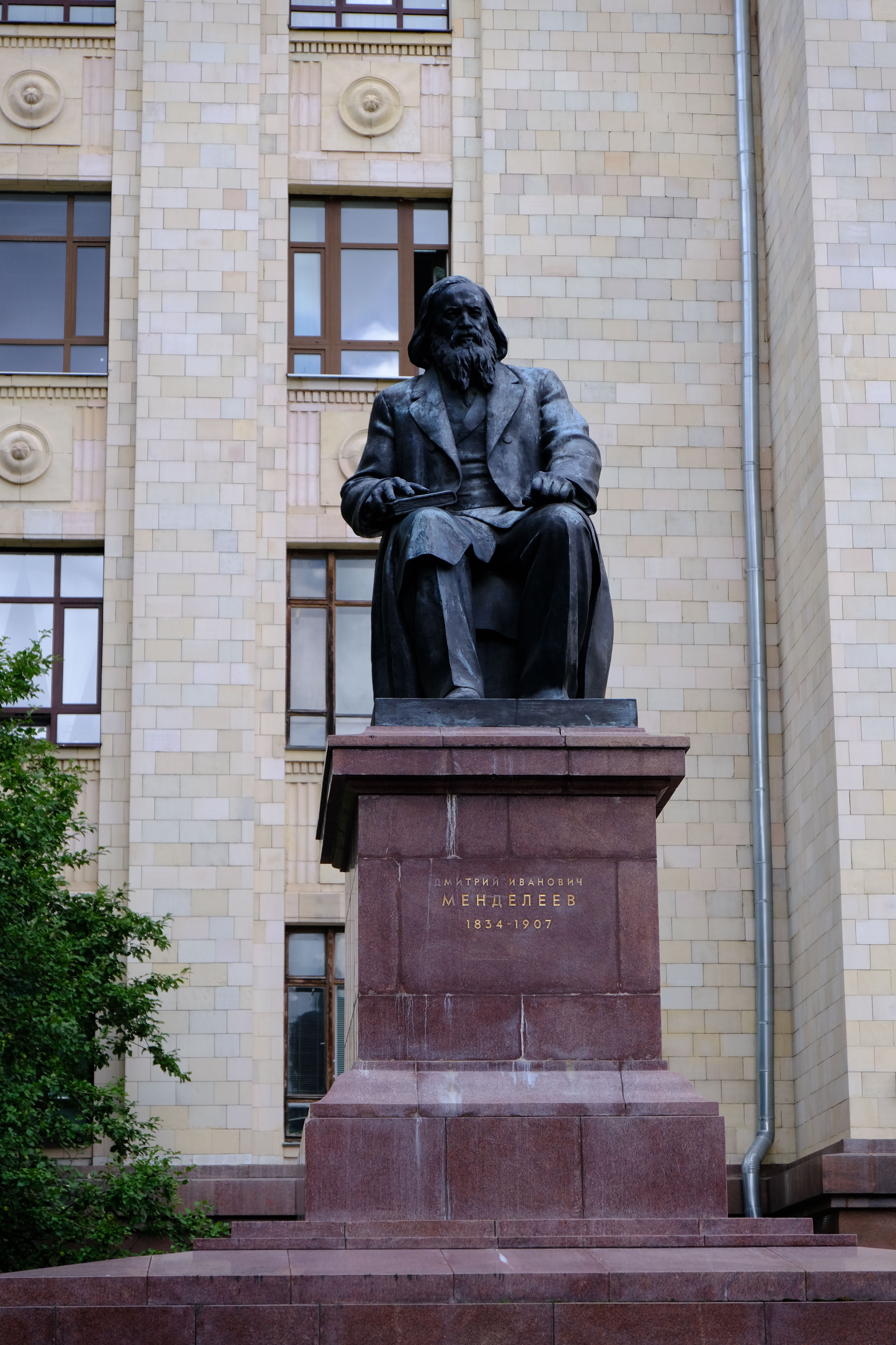 Monument of Dmitri Mendeleev against a classical architectural backdrop in an urban environment.