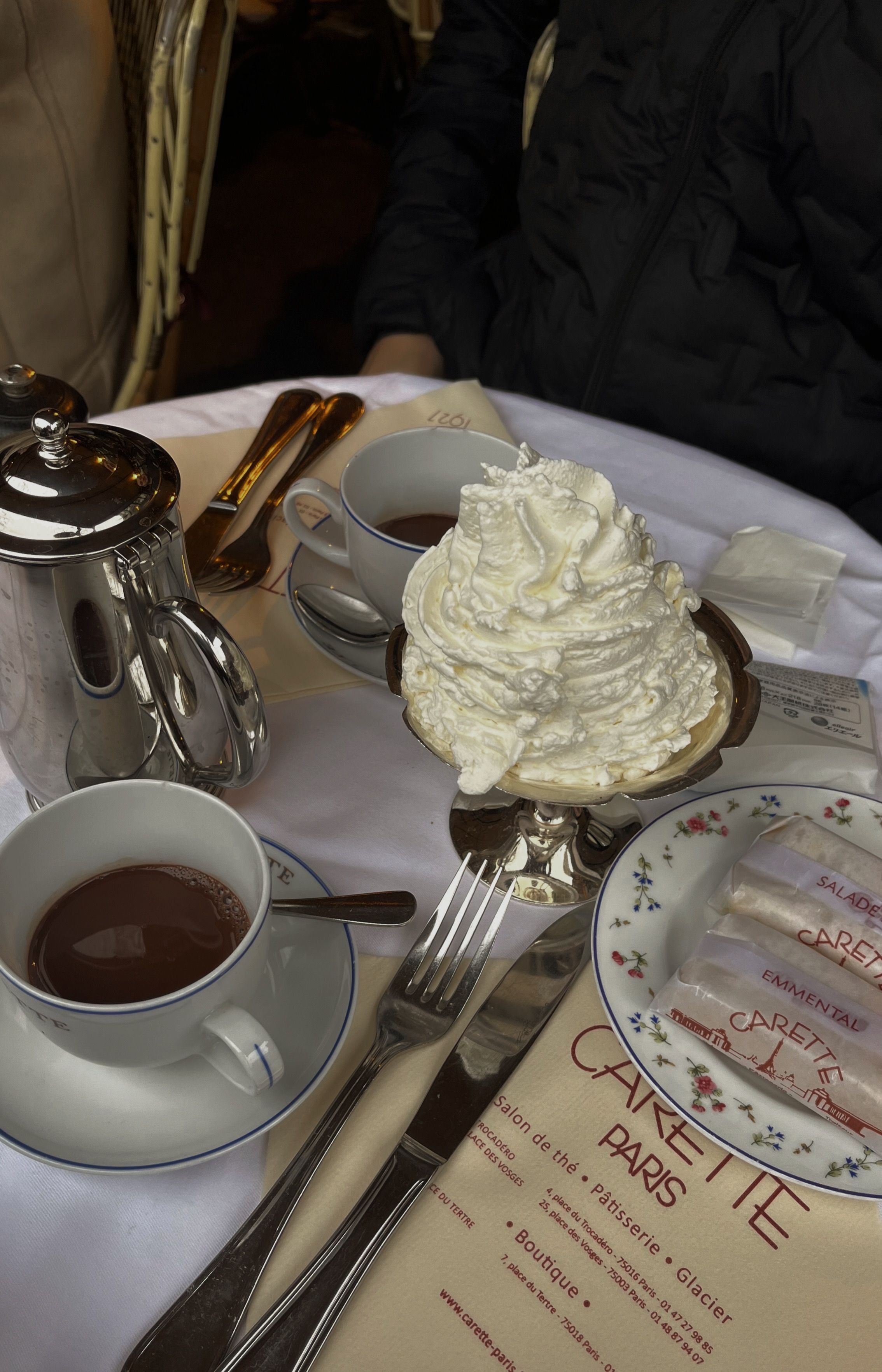 A warm café table in Paris with hot chocolate and whipped cream, perfect for a cozy day.
