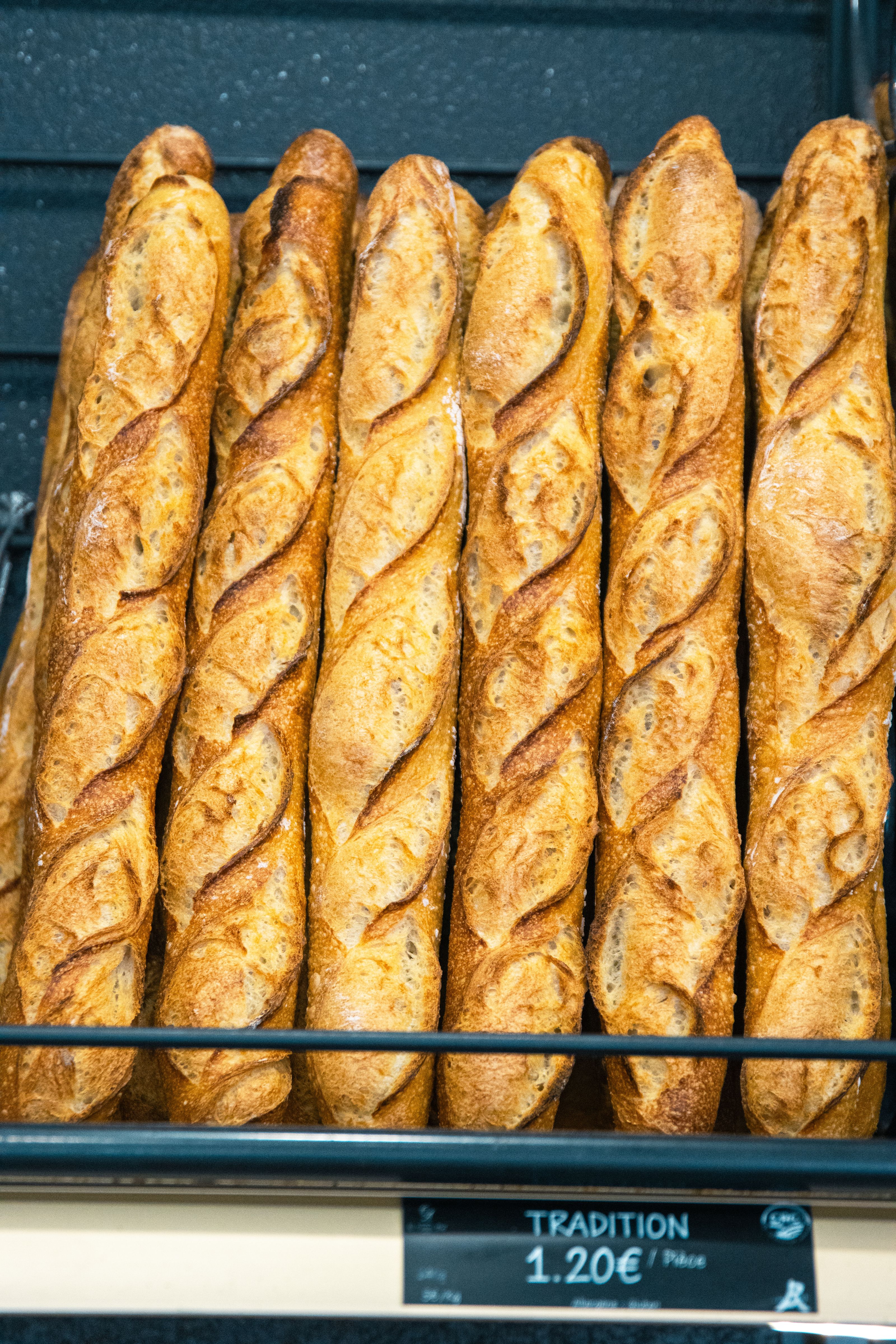 Baguetes francesas crocantes e douradas expostas numa vitrine de padaria. O sabor clássico da Dol-de-Bretagne.