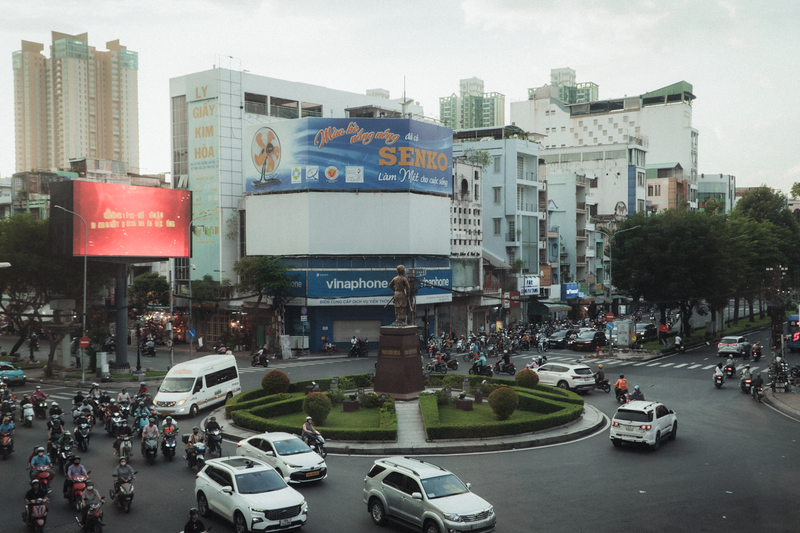 Lively street scene in Ho Chi Minh City featuring traffic and urban architecture.