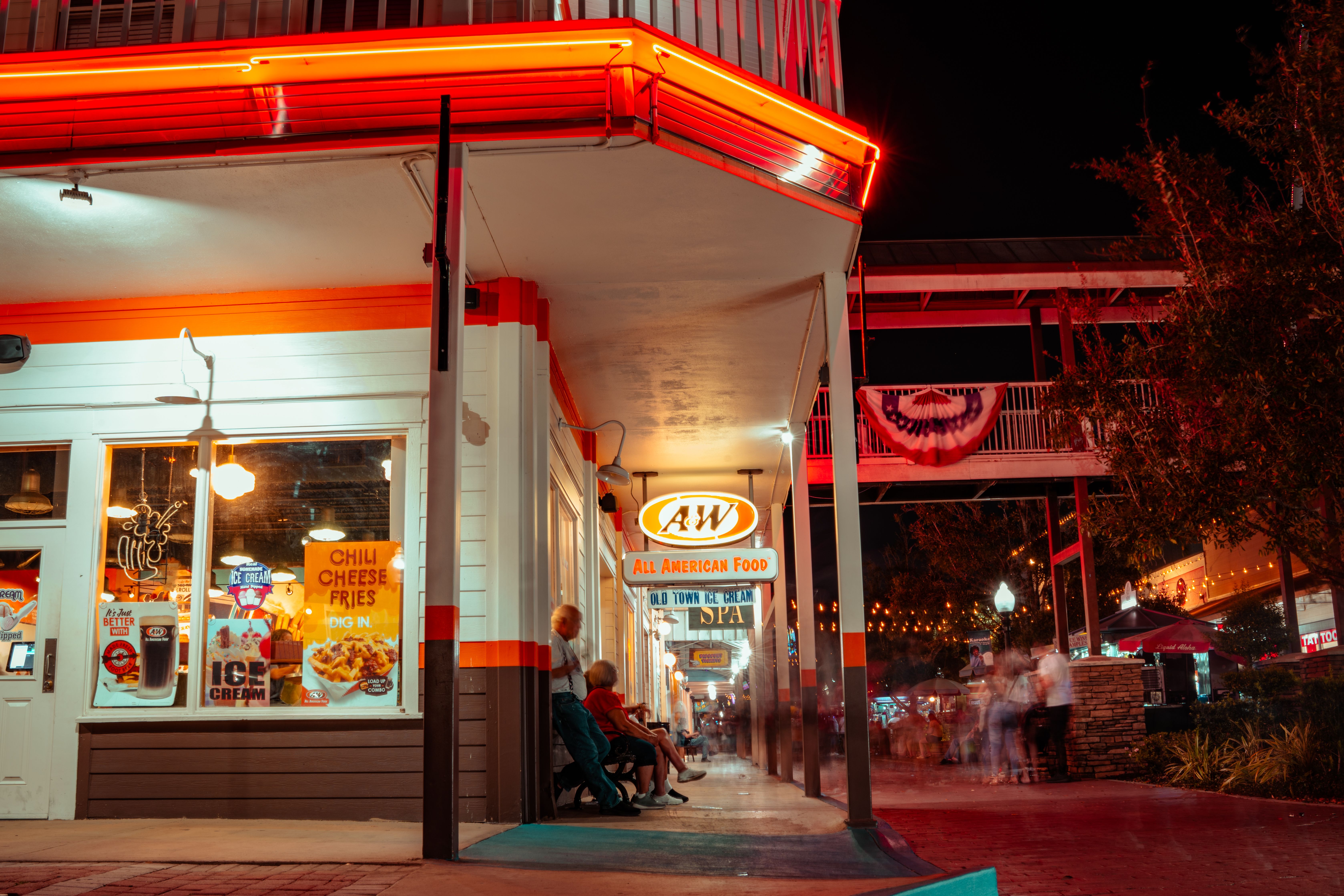 Lively night scene at a classic retro diner with neon lights and bustling street atmosphere.