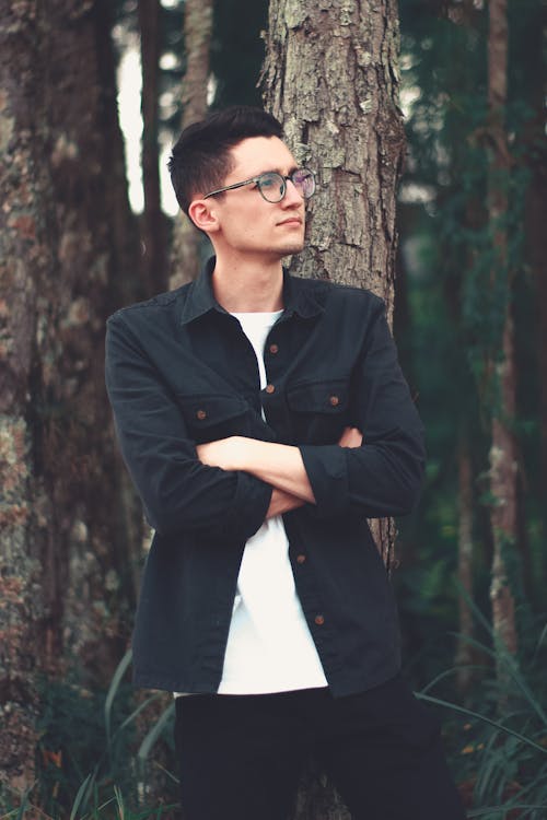 Man In Black Button Up Jacket Standing Beside Tree